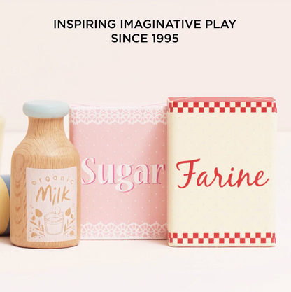 Wooden milk bottle, pink sugar container, and white flour container with text on a white background. TOY BAKERS MIXER SET AND ACCESSORIES | LE TOY VAN