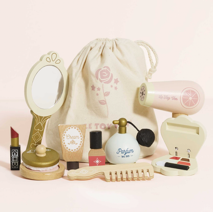 Set of miniature cosmetic items including a mirror, perfume bottle, and other accessories on a light pink background. VANITY STAR BEAUTY KIT & WOODEN ACCESSORIES | LE TOY VAN