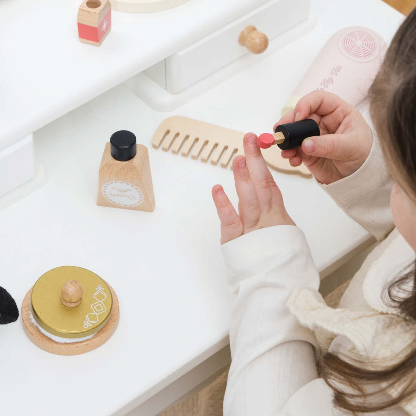 Child playing with toy makeup and wooden toys on a white surface VANITY STAR BEAUTY KIT & WOODEN ACCESSORIES | LE TOY VAN