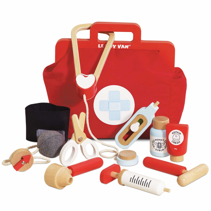 Red toy first aid kit with various medical tools on a white background. VINTAGE DOCTOR ROLEPLAY KIT | LE TOY VAN