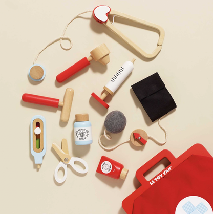 Collection of miniature kitchen items including a knife, bottle, and other tools on a beige background. VINTAGE DOCTOR ROLEPLAY KIT | LE TOY VAN