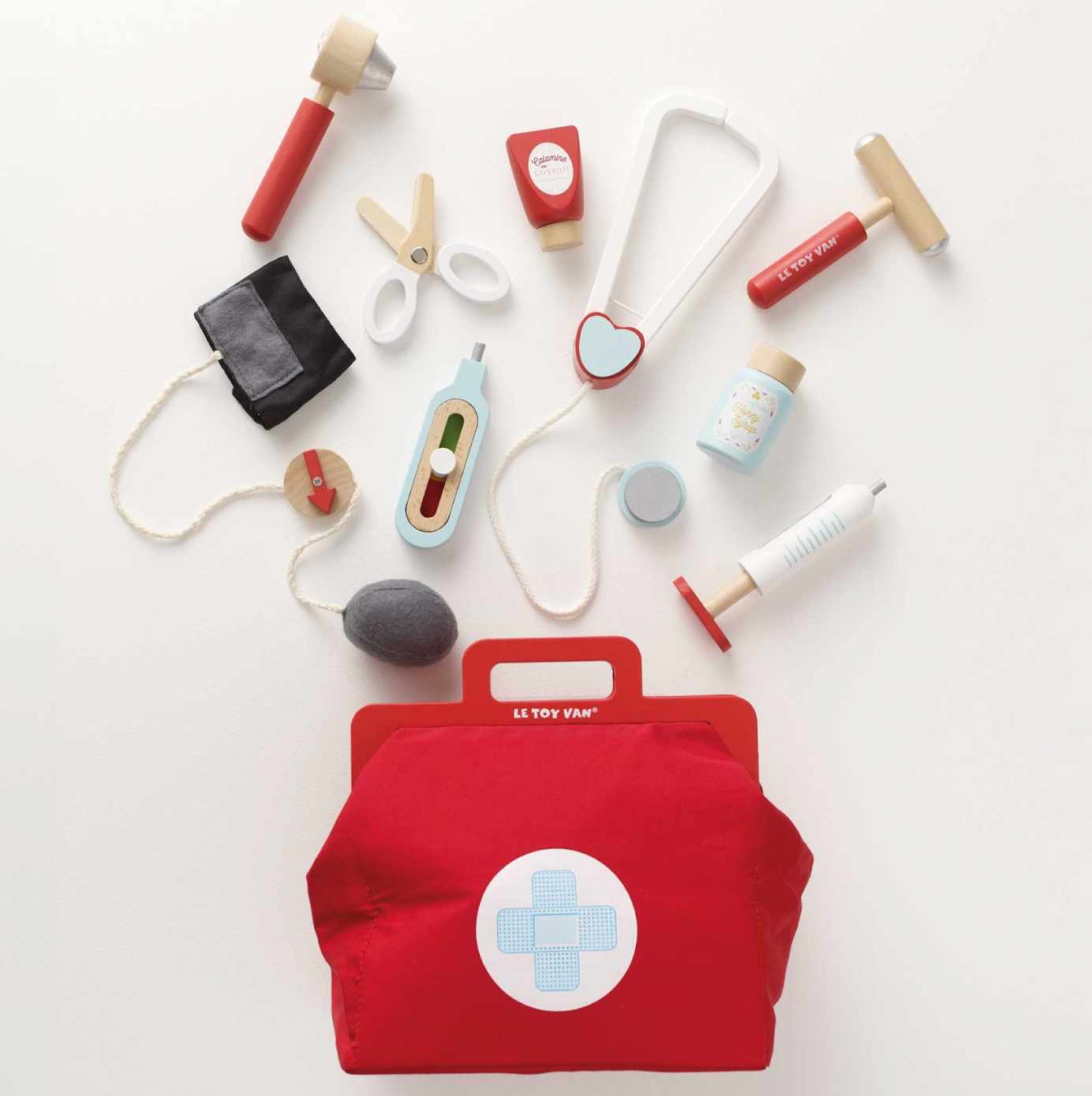 Collection of toy medical tools and a red bag with a cross symbol on a white background. VINTAGE DOCTOR ROLEPLAY KIT | LE TOY VAN