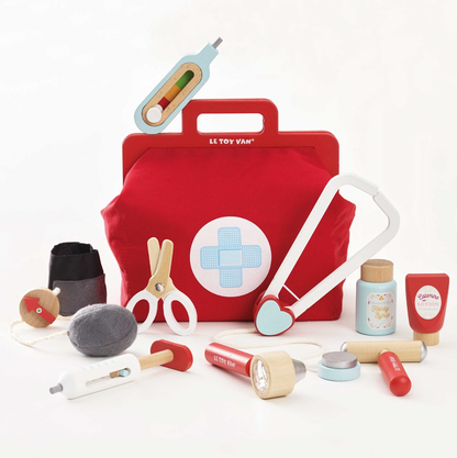 Red toy first aid kit with various medical tools on a white background. VINTAGE DOCTOR ROLEPLAY KIT | LE TOY VAN