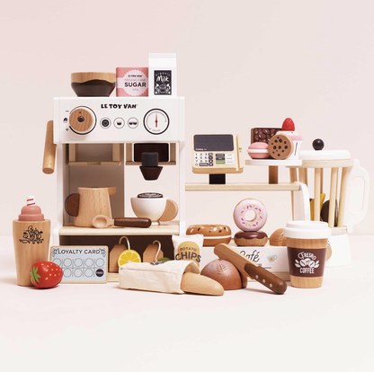 Wooden toy coffee shop set with various items on a light pink background. WOODEN BARISTA CAFE SHOP | LE TOY VAN