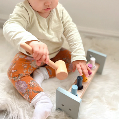 Child playing with wooden toys on a soft surface WOODEN HAMMER BENCH | BIGJIGS