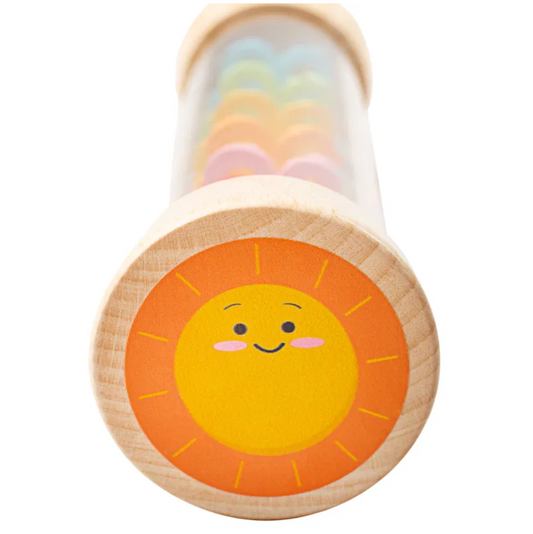 Wooden toy with a smiley sun design on a white background. Wooden toy with colourful beads inside a tube featuring a cloud design on the lid. Rainmaker WOODEN RAINMAKER | BIGJIGS