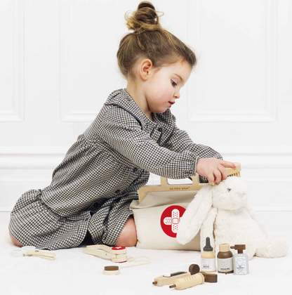 Child playing with toy medical kit and plush rabbit on a white background. WOODEN TOY ANIMAL VET SET | LE TOY VAN
