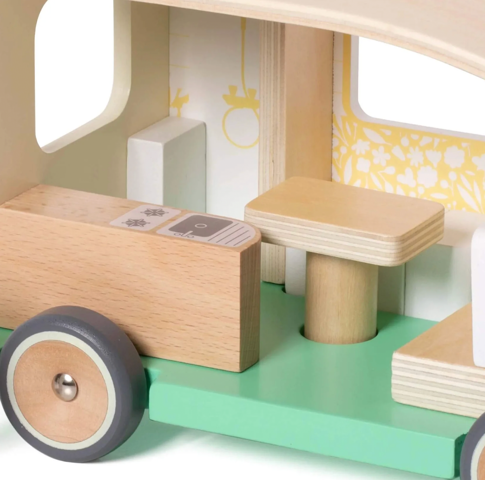 Close-up of a wooden toy vehicle with a green base and beige and gray details. WOODEN TOY CAMPER VAN PLAYSET | CLASSIC WORLD