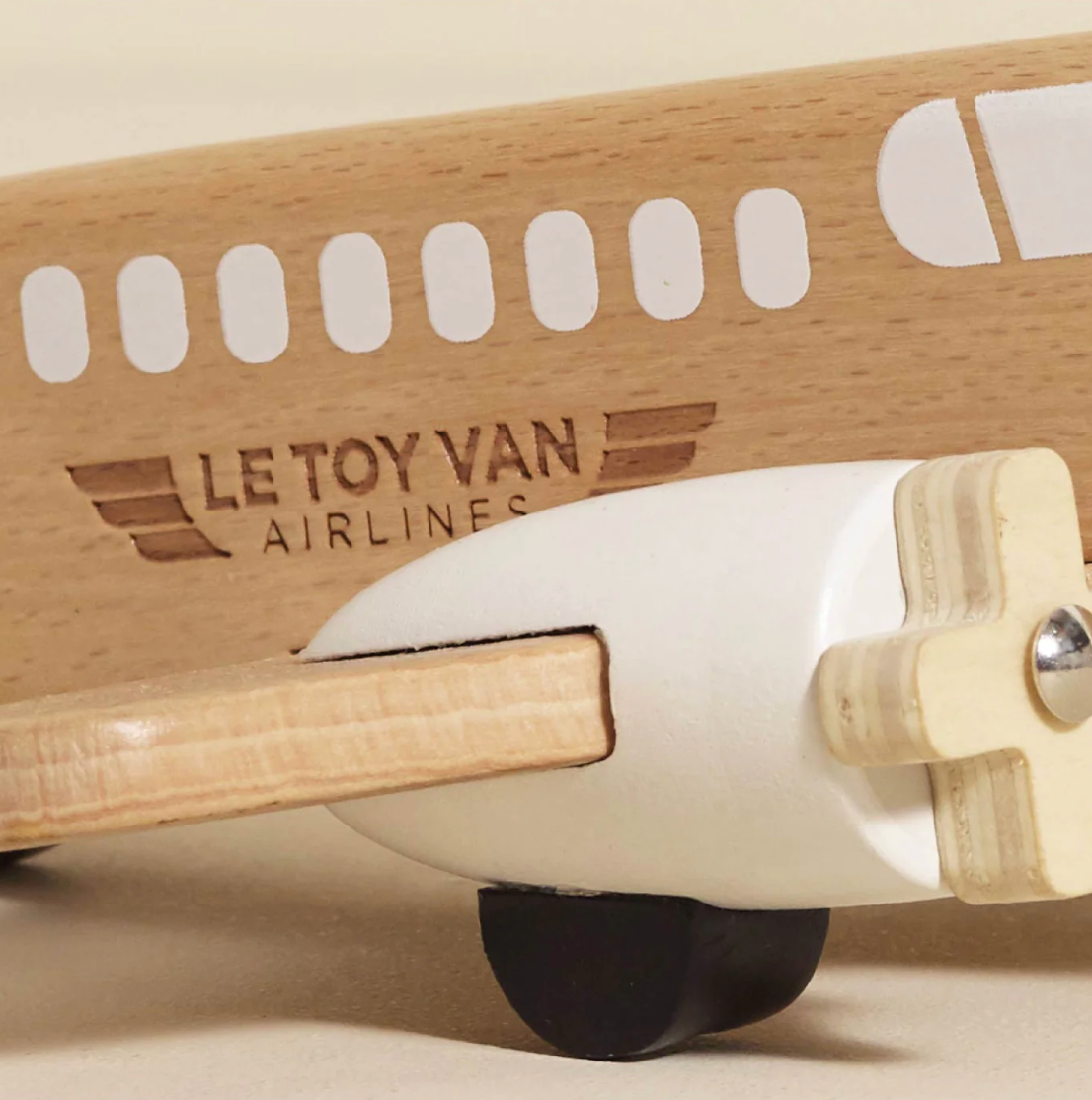 Wooden toy airplane with 'Le Toy Van' branding on a beige background. WOODEN TOY PLANE | LE TOY VAN