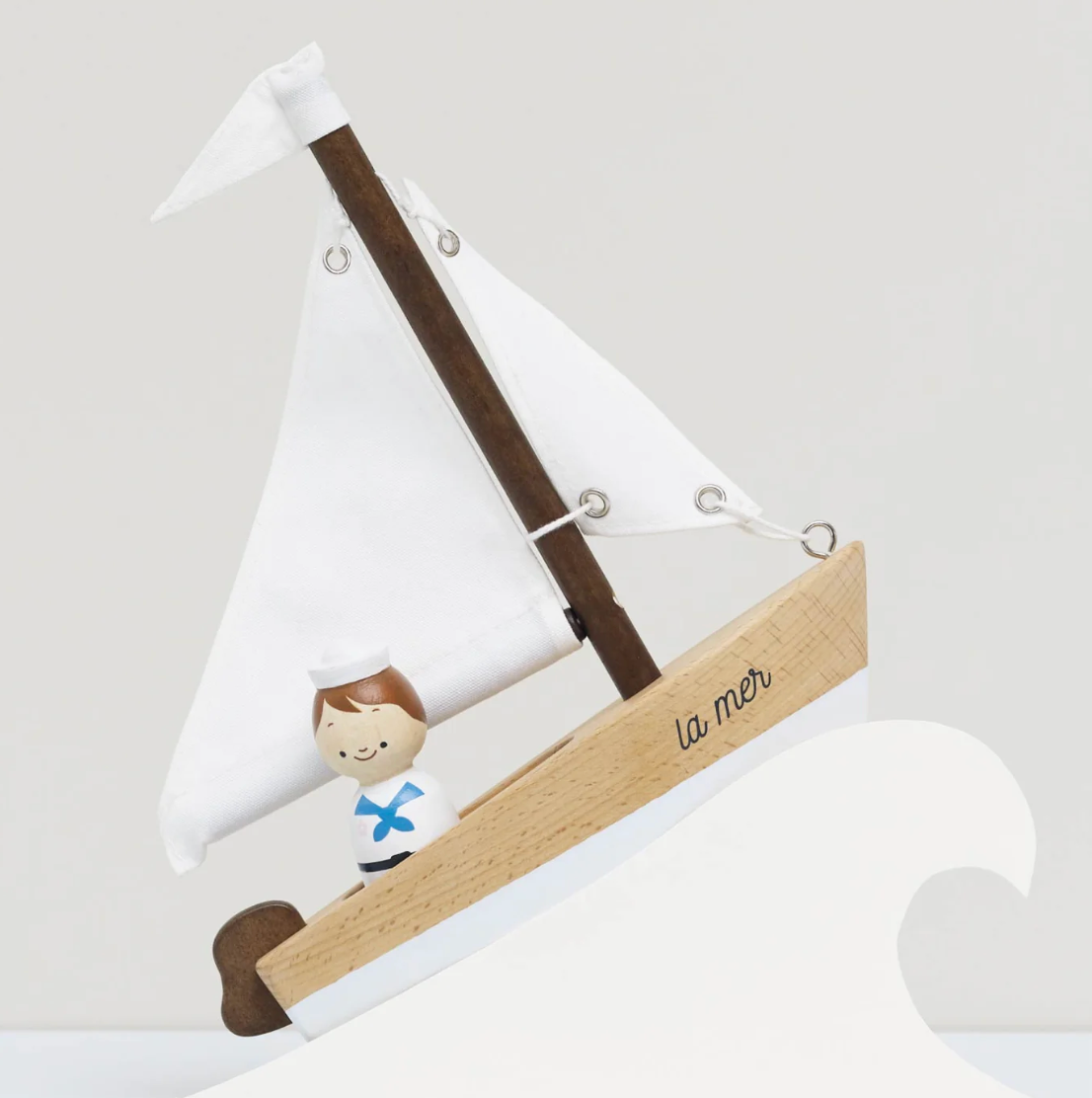 Decorative sailboat with a figure of a boy and 'la mer' on a white background . WOODEN TOY SAILING BOAT & CAPTAIN | LE TOY VAN