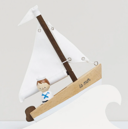 Decorative sailboat with a figure of a boy and 'la mer' on a white background . WOODEN TOY SAILING BOAT & CAPTAIN | LE TOY VAN