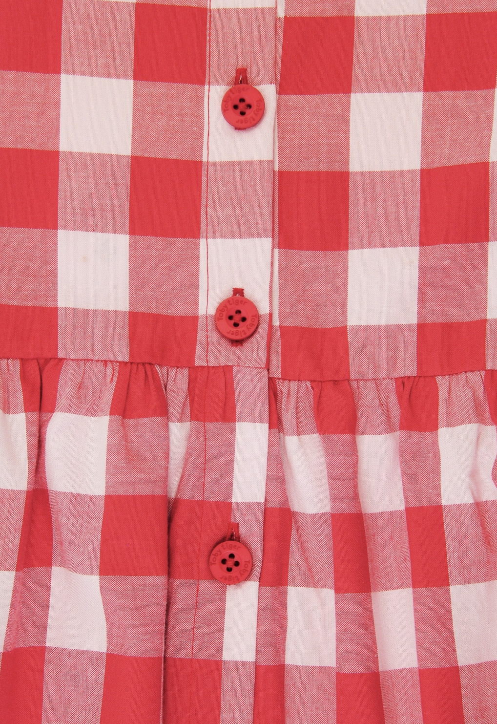 Close-up view of the premium organic woven cotton gingham check fabric and gathered waistline.
