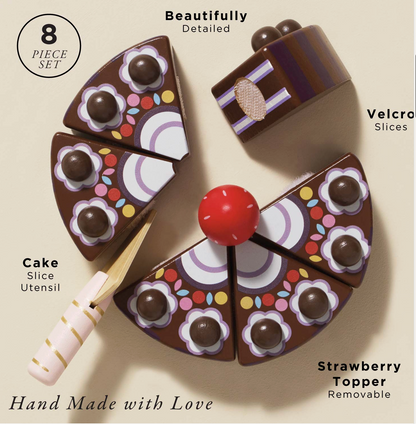 A wooden cake server cutting a slice from the Le Toy Van toy chocolate gateau, showcasing the velcro attachments.